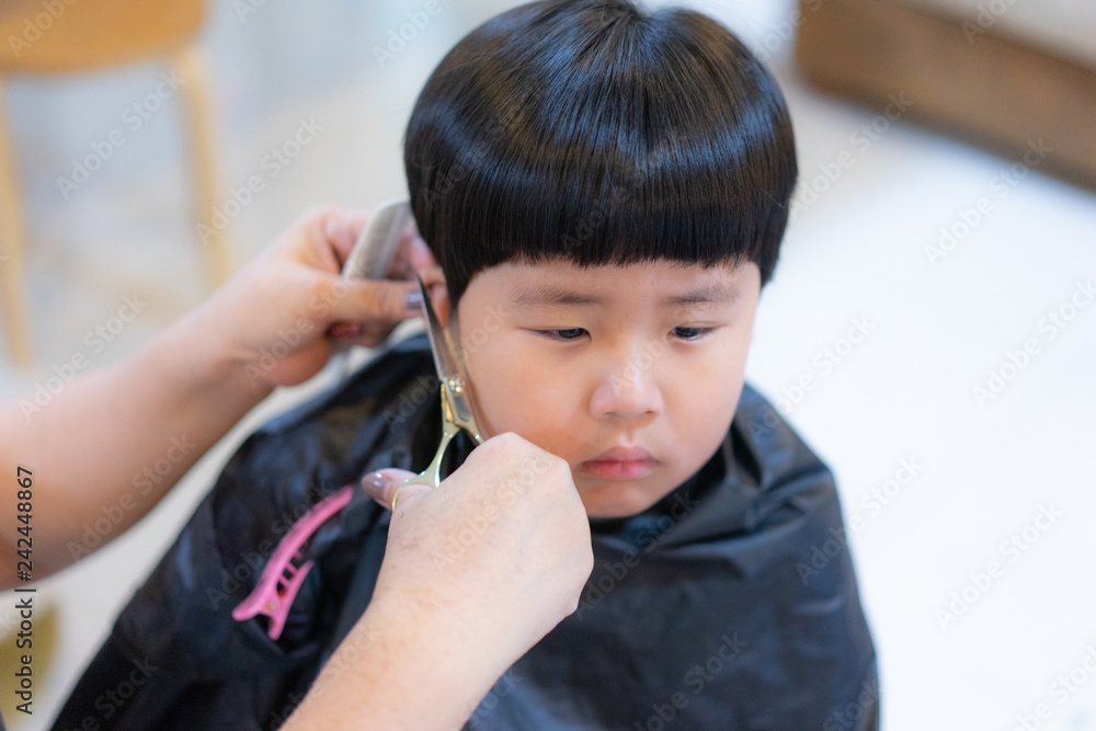 Grandmother is cutting hair of her grandson at home. Grandmother is cutting hair of her grandson at home.