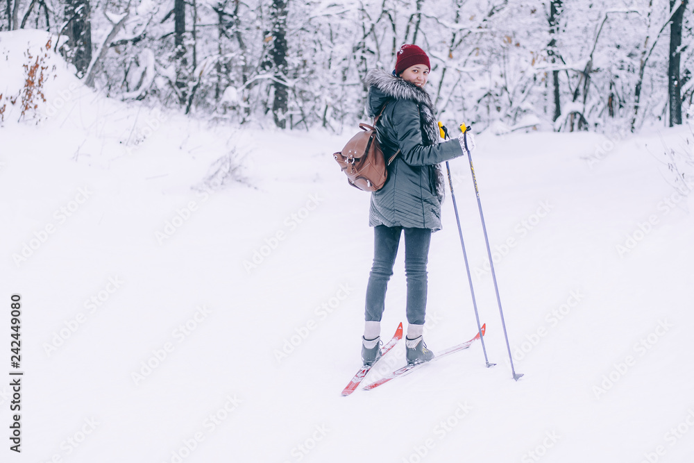 Girl in the winter forest is skiing