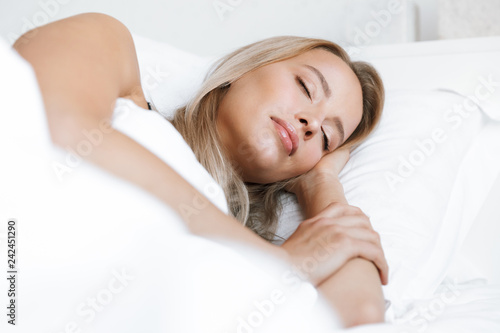 Young woman in lingerie underwear lies in bed at home sleeping.