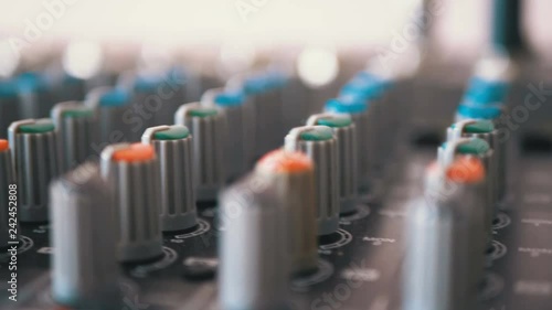 Control knobs on a sound mixing console. Fade sliders controls on audio mixer console in music studio close-up. photo