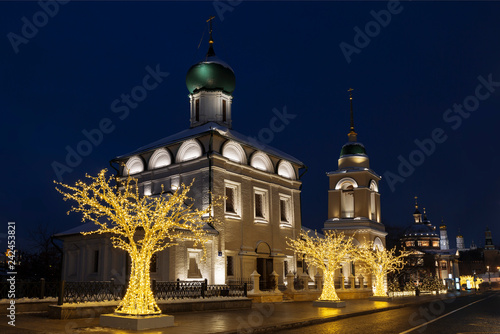 Varvarka street with churches of St. Barbara with bell tower and Maxim the Confessor (Maxim the blessed) at Christmas and New year's in the evening. Moscow, Russia