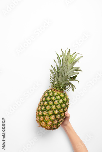 cropped view of woman holding organic pineapple in hand on white background