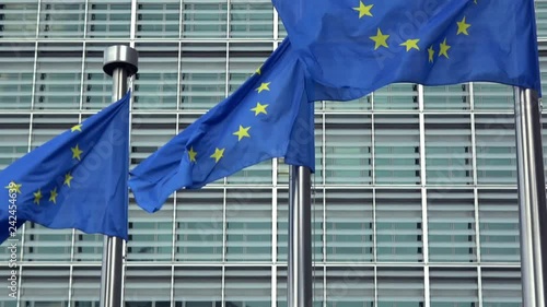 4K. European Union flags in a row waving in the wind in front of European Commission, Berlaymont building in central Brussels city, Belgium photo