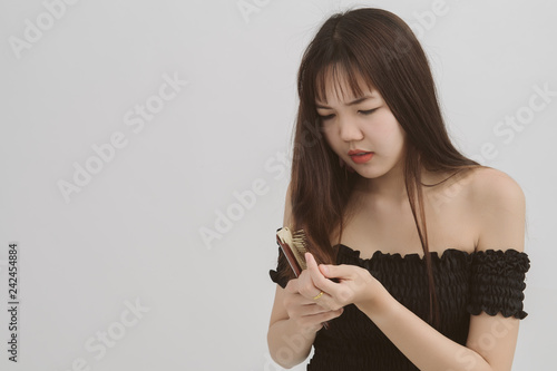 Portrait of asian woman long hair with a comb and problem hair on white background. This image for hair loss concept. Free from copy space.