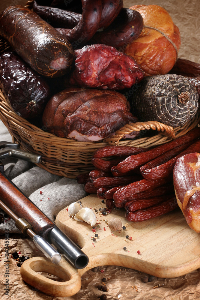 Fototapeta premium Wędzone wędliny tradycyjne. Kompozycja tradycyjnych kiełbas i szynek. 