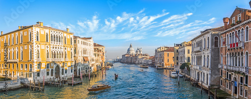 Grand Canal in Venice, Italy. Wide view of the main street panorama of the major street of Venice with motor boats with beautiful picturesque clouds in the sky. Basilica di Santa Maria della Salute. © aapsky