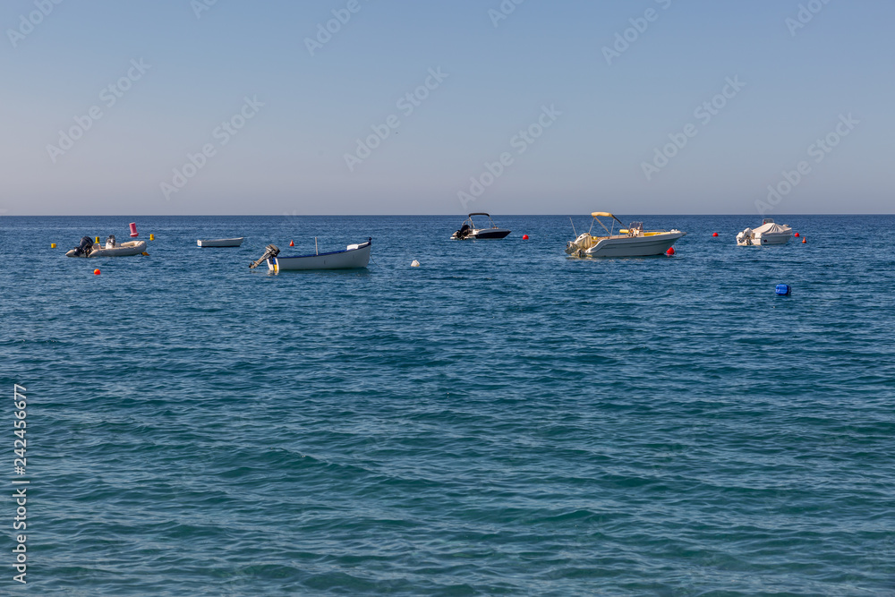 Far view of some small yachts in the sea near the beach