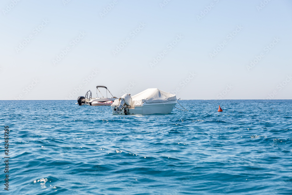 Naklejka premium Two yachts moored in the sea near a shore