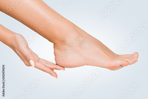 Schilderij op canvas Woman touching her soft heel skin on blue background