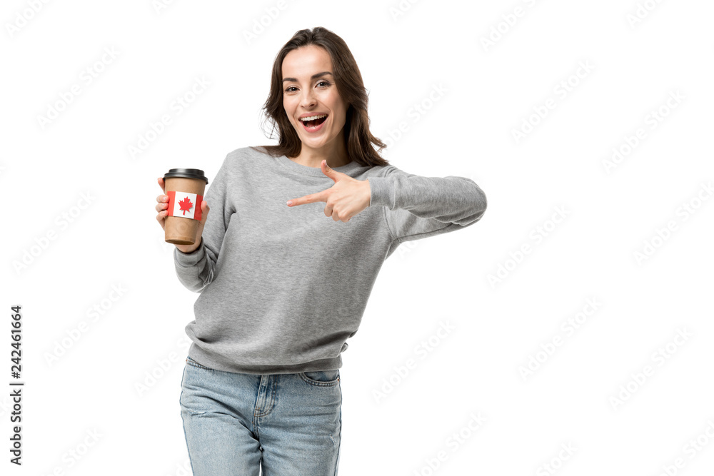 smiling woman pointing with finger at coffee cup with canadian flag sticker isolated on white smiling woman pointing with finger at coffee cup with canadian flag sticker isolated on white