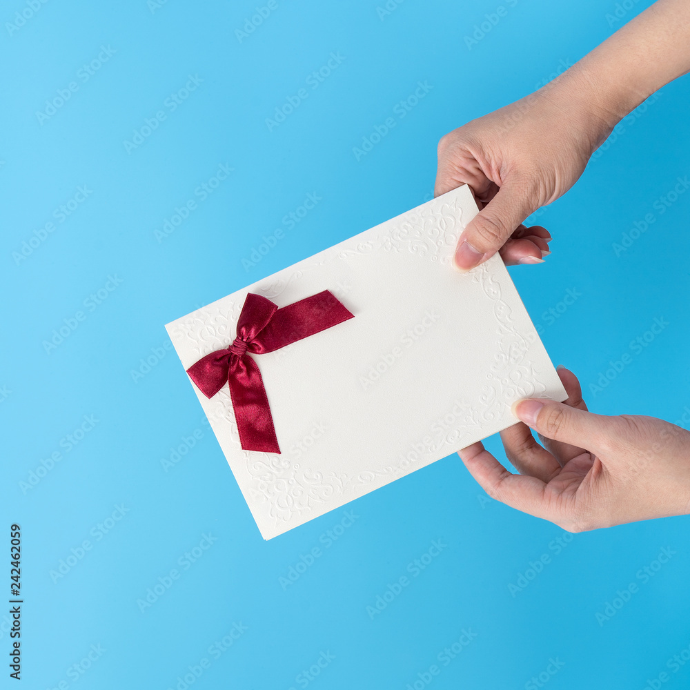 A young woman is giving a gift card with greeting messgae, concept of holiday and celebrate for festival surprising, copy space, top view A young woman is giving a gift card with greeting messgae, concept of holiday and celebrate for festival surprising, copy space, top view