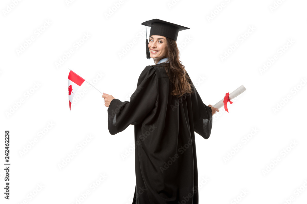 attractive smiling female student in academic gown holding canadian flag and diploma isolated on white attractive smiling female student in academic gown holding canadian flag and diploma isolated on white