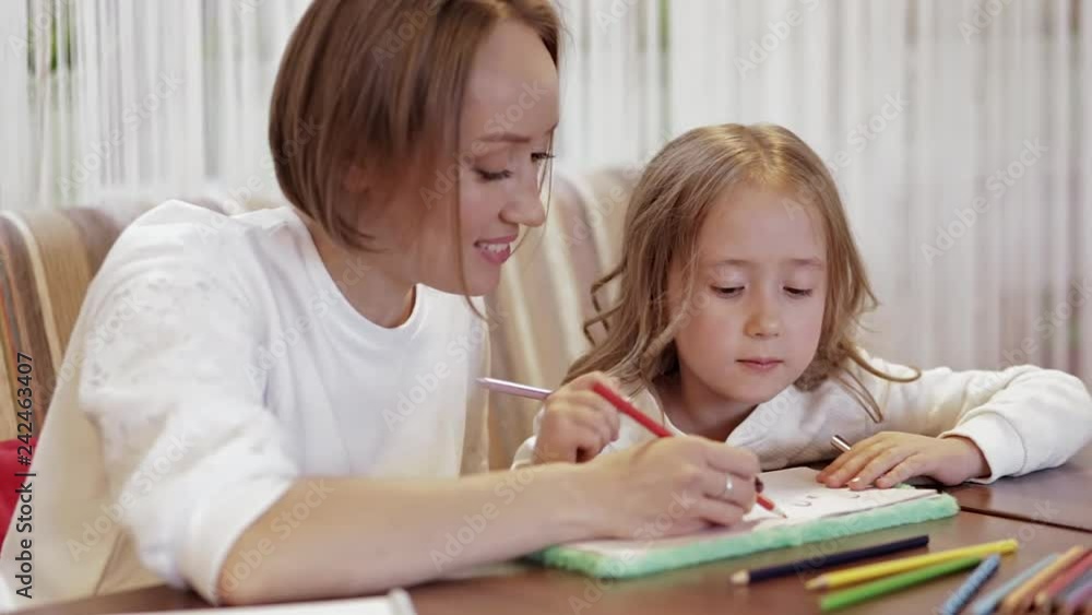 Young Positive Cute Mother Doing Drawing With Her Little Beautiful Daughter In A Cafe At The Weekend Young Positive Cute Mother Doing Drawing With Her Little Beautiful Daughter In A Cafe At The Weekend