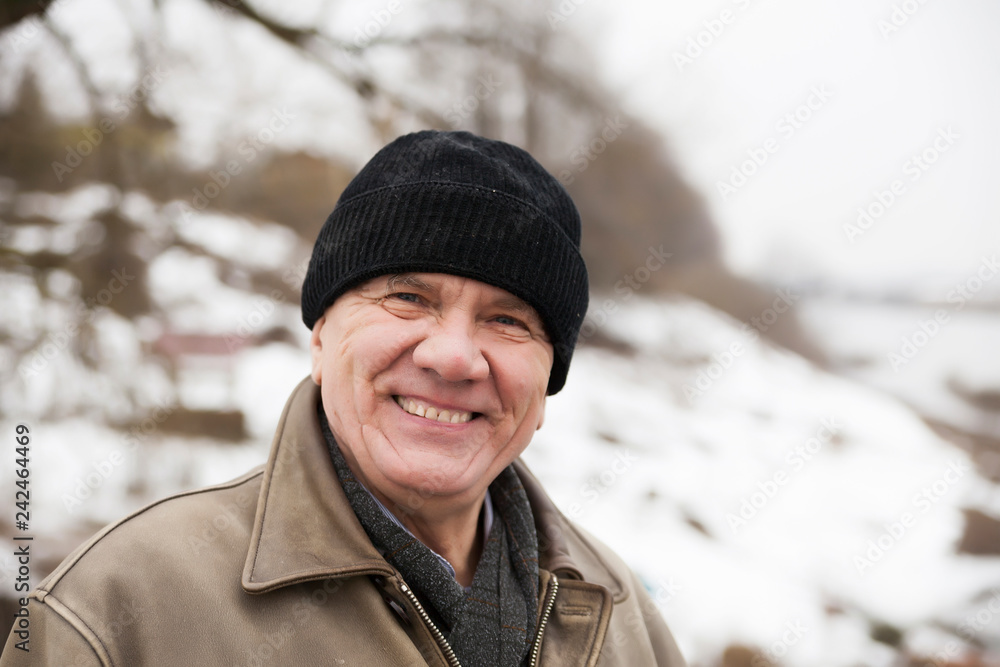 elderly man in hat on background of winter. elderly man in hat on background of winter.