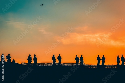 Sculptures of saints in Vatican  silhouette on the orange sky background
