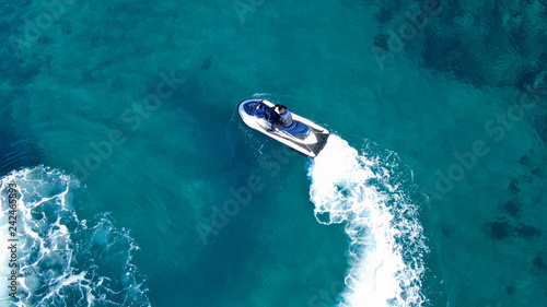 Aerial top view of jet-ski cruising in low speed in mediterranean emerald clear waters