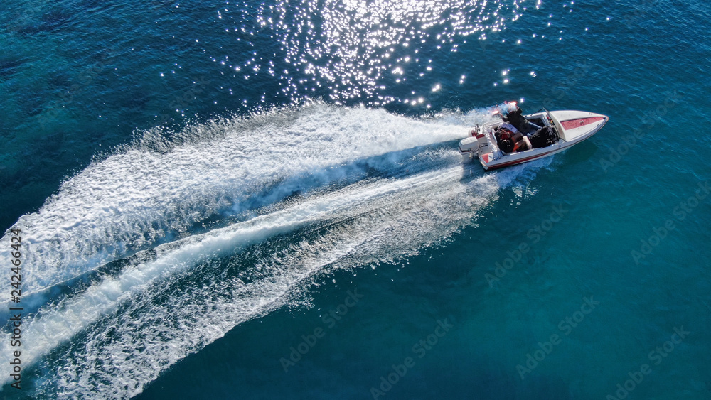 Aerial drone photo of power boat cruising in high speed in deep blue sea Aerial drone photo of power boat cruising in high speed in deep blue sea