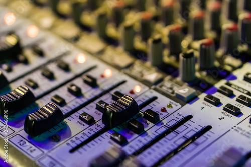 Foto Selective focus on knops of electronic sound mixer in the foreground of the outd