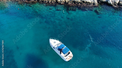 Fototapeta Naklejka Na Ścianę i Meble -  Aerial bird's eye view photo taken by drone of boat cruising in caribbean tropical beach with turquoise - sapphire waters