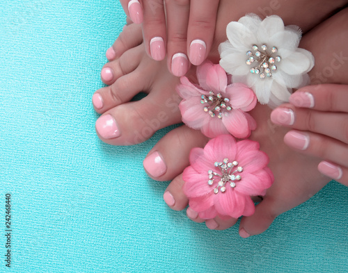 Beautiful pink manicure and pedicure with flowers photo