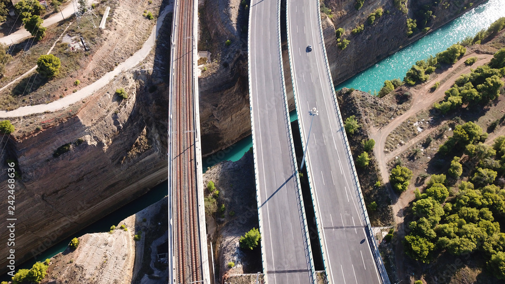 Aerial bird's eye view photo taken by drone of Corinth Canal of Isthmos or Isthmus and road network motorway connecting mainland with Peloponnese, Greece