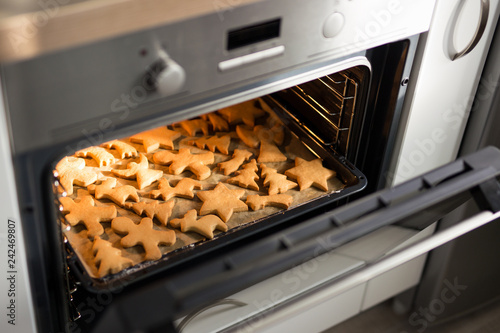 cookies or gingerbreads in modern oven in bright kitchen
