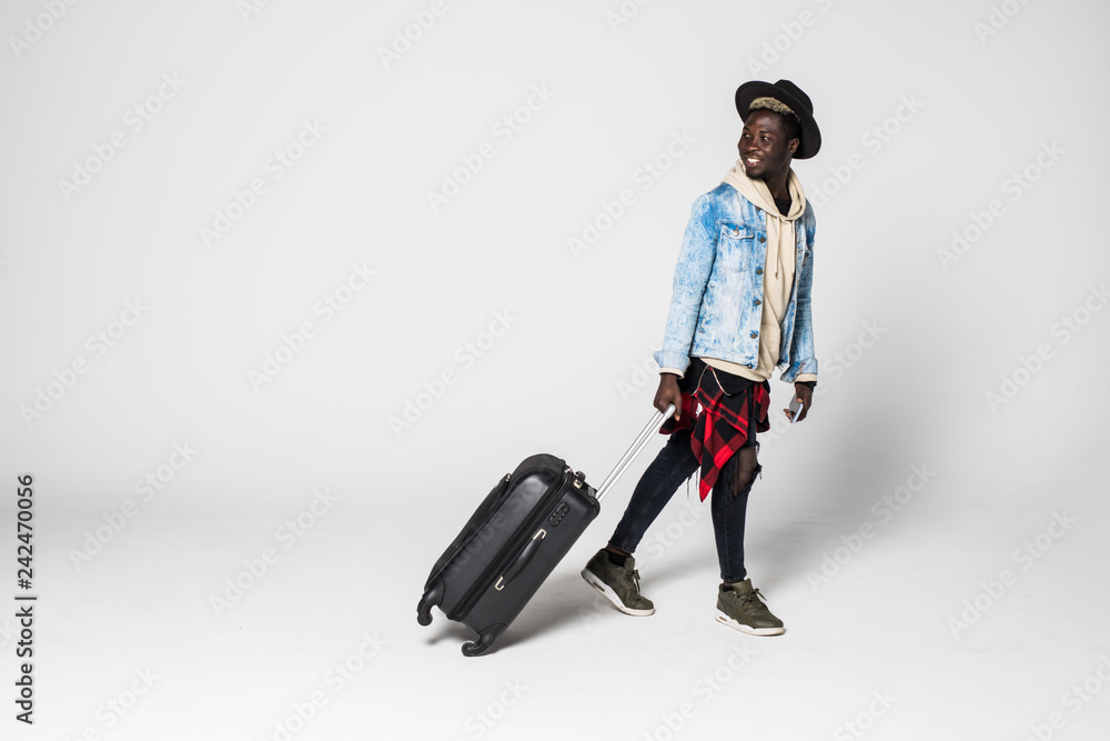 Full body side portrait of smiling african man walking with suitcase on white background Full body side portrait of smiling african man walking with suitcase on white background