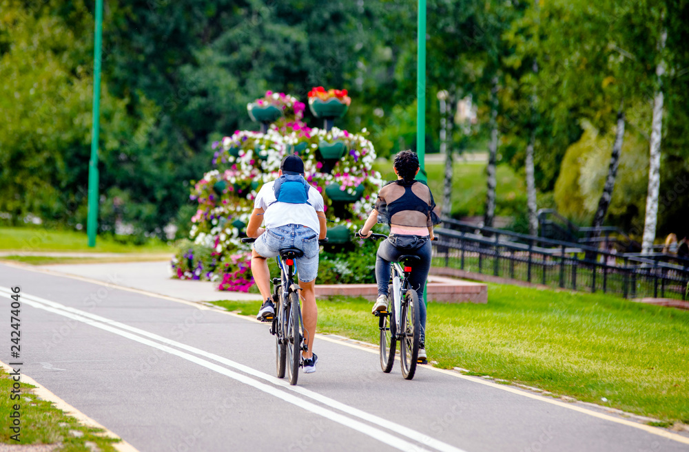Fototapeta premium Cyclists ride on the bike path in the city Park 