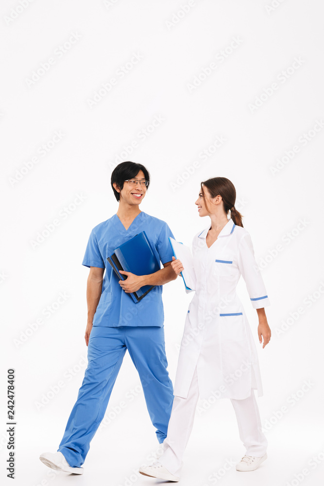 Confident young multiethnic doctors couple standing Confident young multiethnic doctors couple standing