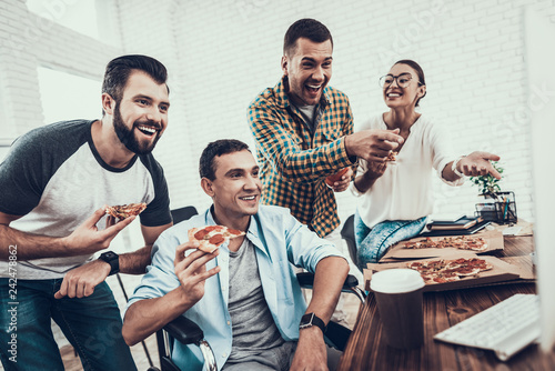 Young People Have Lunch with Pizza in Office. © VadimGuzhva