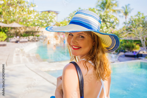 Woman walking by swimming pools on vacation in luxury resort