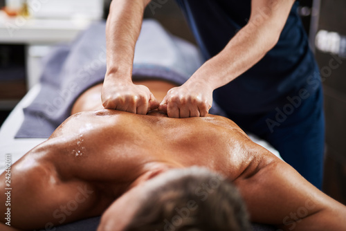 Obraz na plátně Professional masseur massaging man back at wellness center