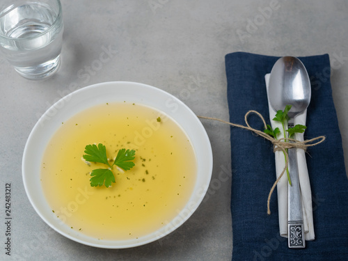 Foto Klare Suppe in einem weißen Teller mit Petersilie, Fastenkur, Abhnehmen, Diät