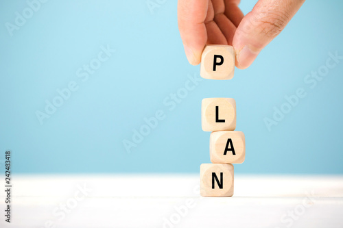 Hand hold wooden cube with PLAN word. The concept of planning in business. photo