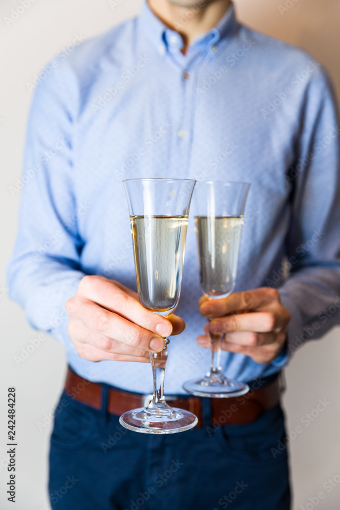 Valentines day romantic date night, handsome man holding two champagne glasses for couple. Valentines day romantic date night, handsome man holding two champagne glasses for couple.