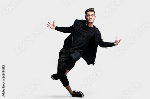 Fotografie, Obraz Dark-haired stylish young dancer wearing a black sweatshirt and black pants make