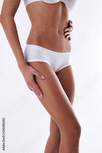 Young lady demonstrating beautiful slim body on white background