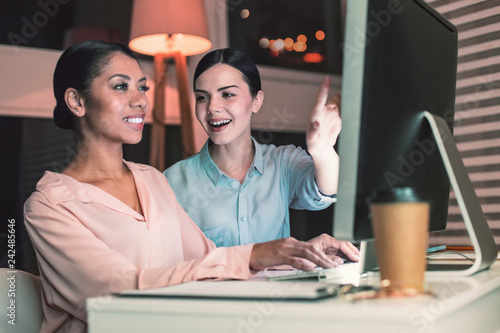 Beautiful female person pointing at computer