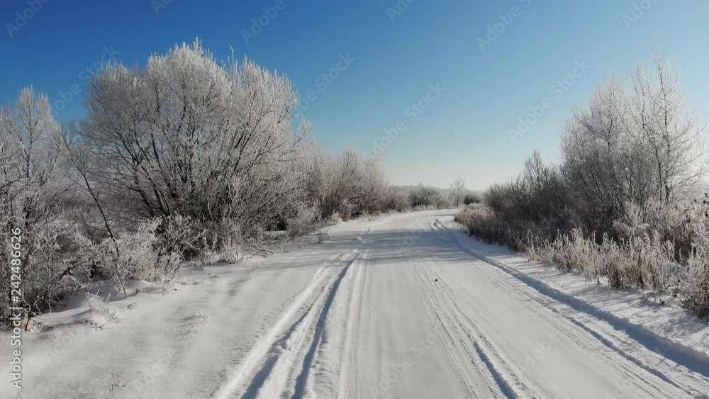 Smooth flight ahead above a snowy road. Trees and shrubs are covered with snow, winter beauty Smooth flight ahead above a snowy road. Trees and shrubs are covered with snow, winter beauty