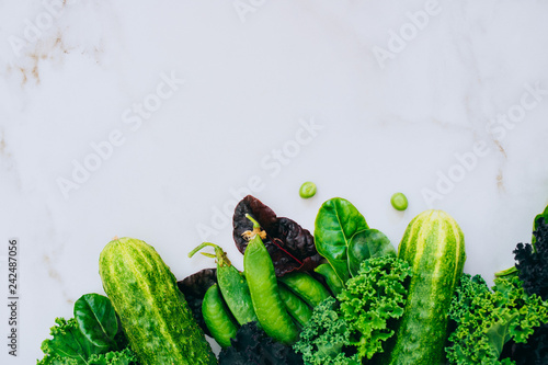 Frame of fresh green vegetables on a marble background  copy space  flay lay  top view