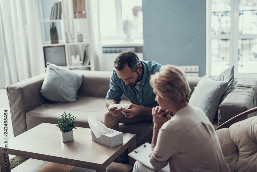 Calm psychotherapist sitting next to her thoughtful client Calm psychotherapist sitting next to her thoughtful client