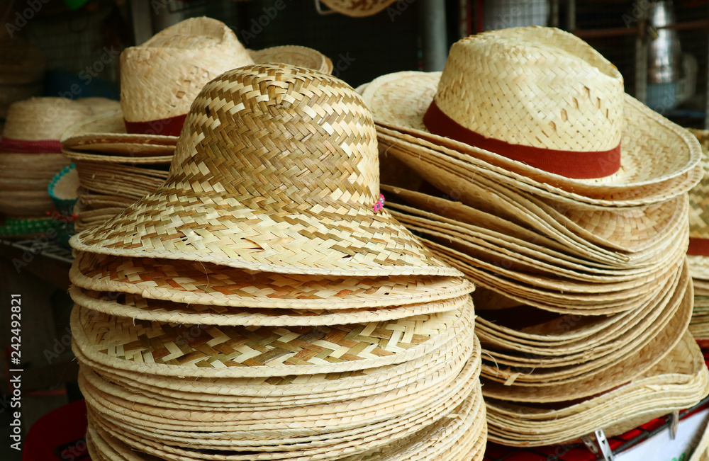 Stacks of natural color beautiful straw hats in the hat shop 