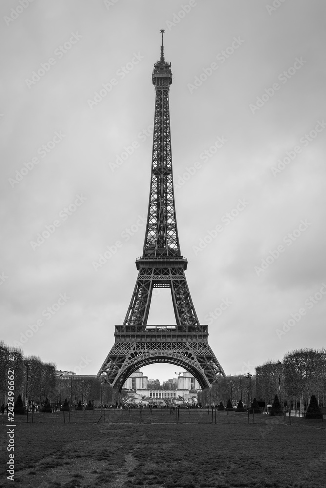 Eiffel Tower seen from Champ de Mars. UNESCO World Heritage Site. Paris landmark in black and white.