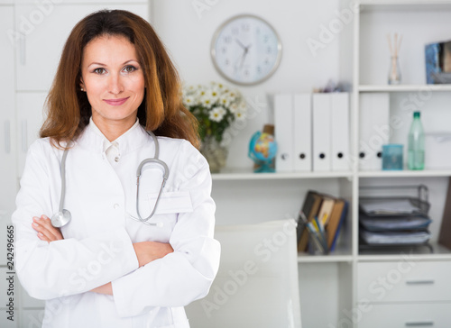 Portrait of female doctor who is working and posing on her workplace