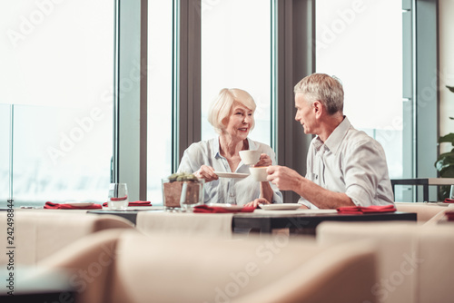 Attractive retired couple having breakfast in a cafe together