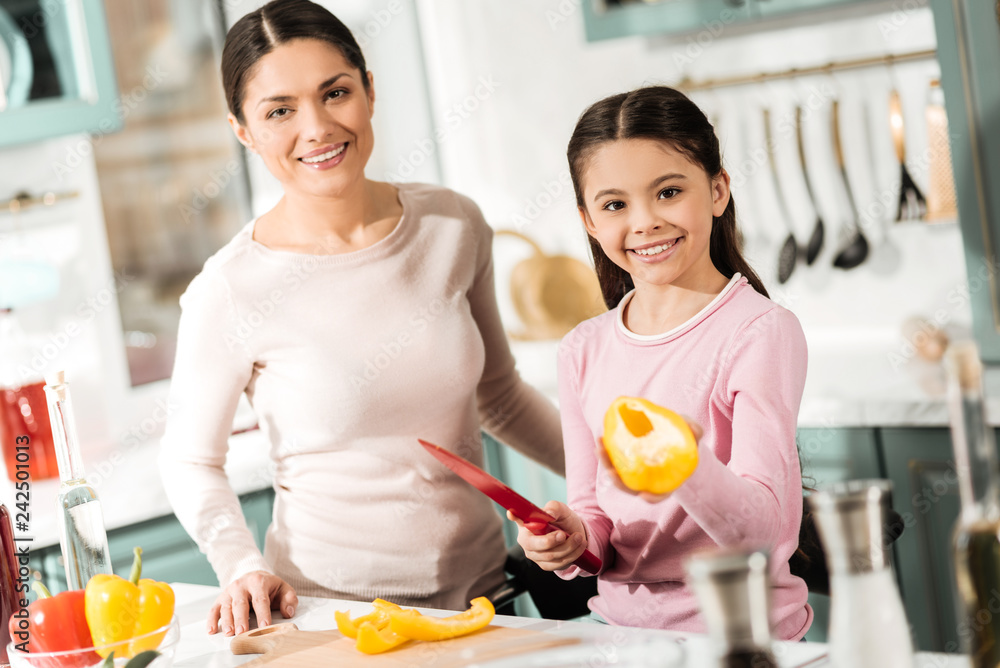 Amazing brunette standing near her kid in kitchen Amazing brunette standing near her kid in kitchen