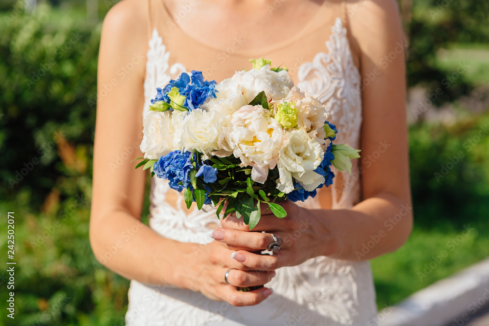 Bride holding wedding bouquet ourdoors. Close up. Bride holding wedding bouquet ourdoors. Close up.