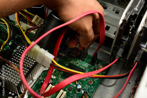 Engineer is repairing electric wire computer hardware in a computer CPU