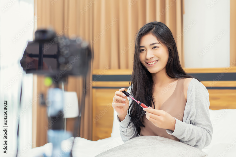 Young Asian cute artist woman beauty vlogger or blogger doing a cosmetic makeup tutorial vlog with brushes looking camera, recording viral clip to share on social media live streaming for Internet Young Asian cute artist woman beauty vlogger or blogger doing a cosmetic makeup tutorial vlog with brushes looking camera, recording viral clip to share on social media live streaming for Internet