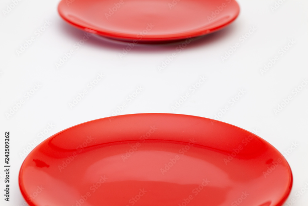 Red plates on the white wooden table.Top view. Red plates on the white wooden table.Top view.